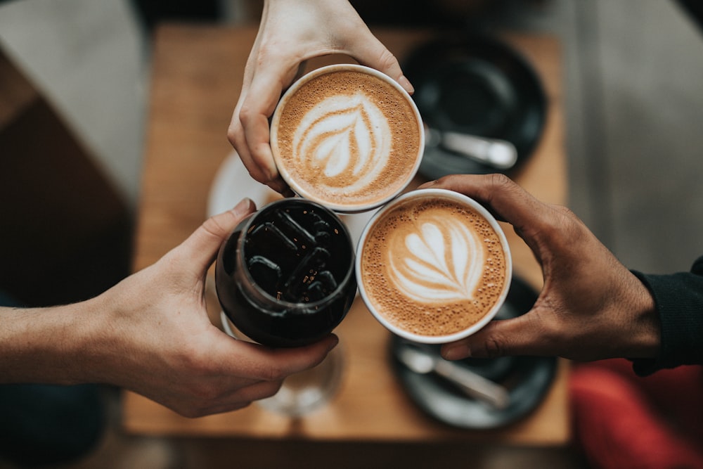 Two friends holding lattes together